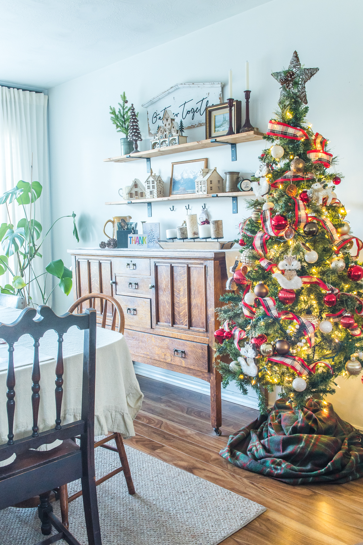 Christmas tree beside an antique buffet