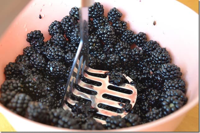 blackberries being smashed with a masher