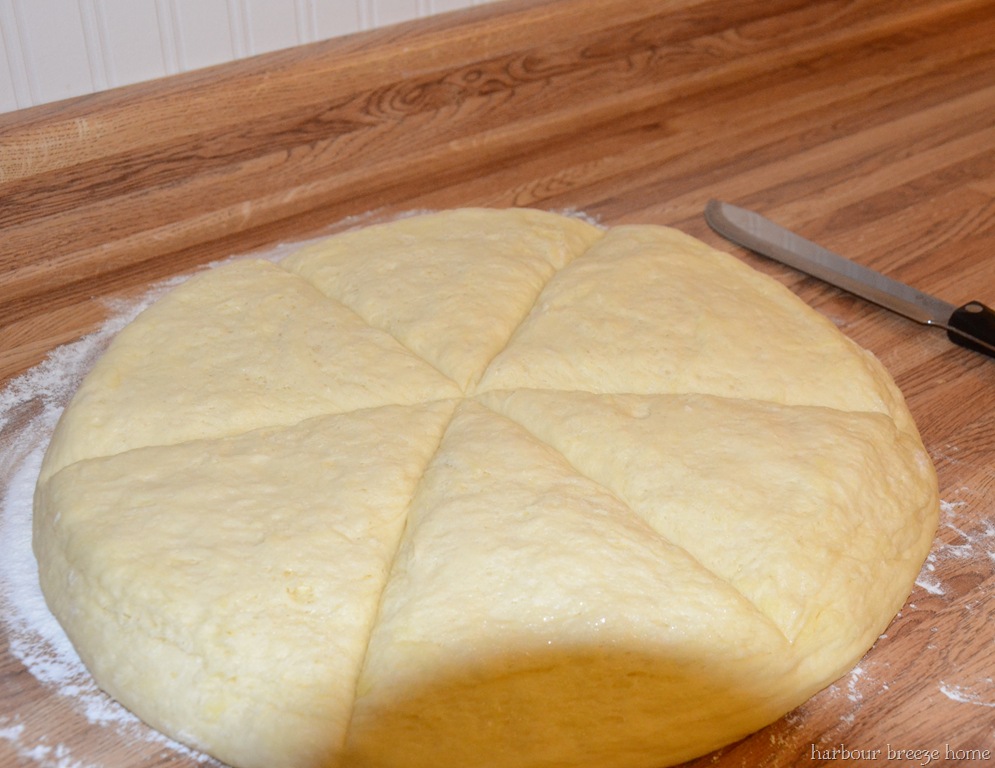 overnight buns being cut before they are formed into crescent rolls