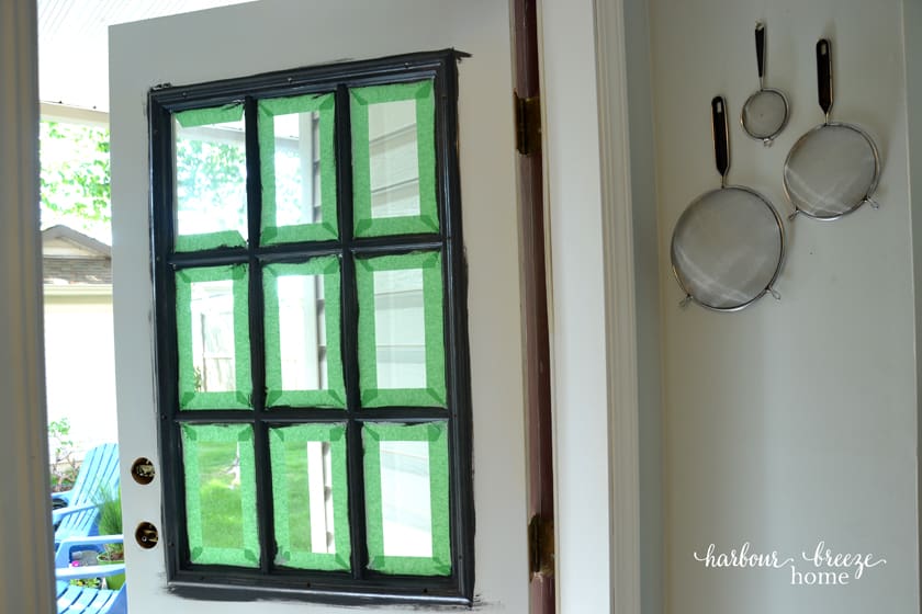 Front door with painters tape around the window panes.