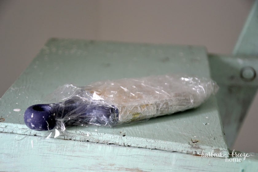 A paint brush wrapped in saran wrap