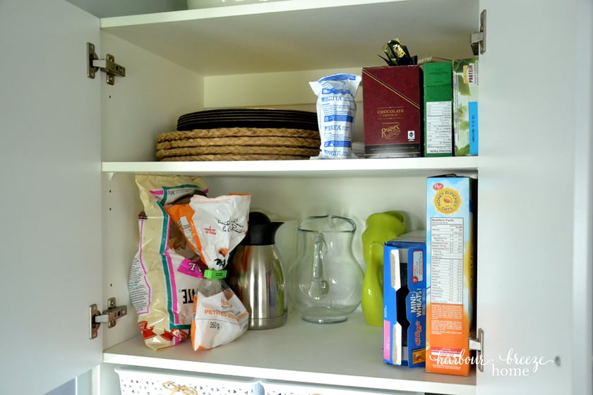 the top shelves of a cupboard pantry organized