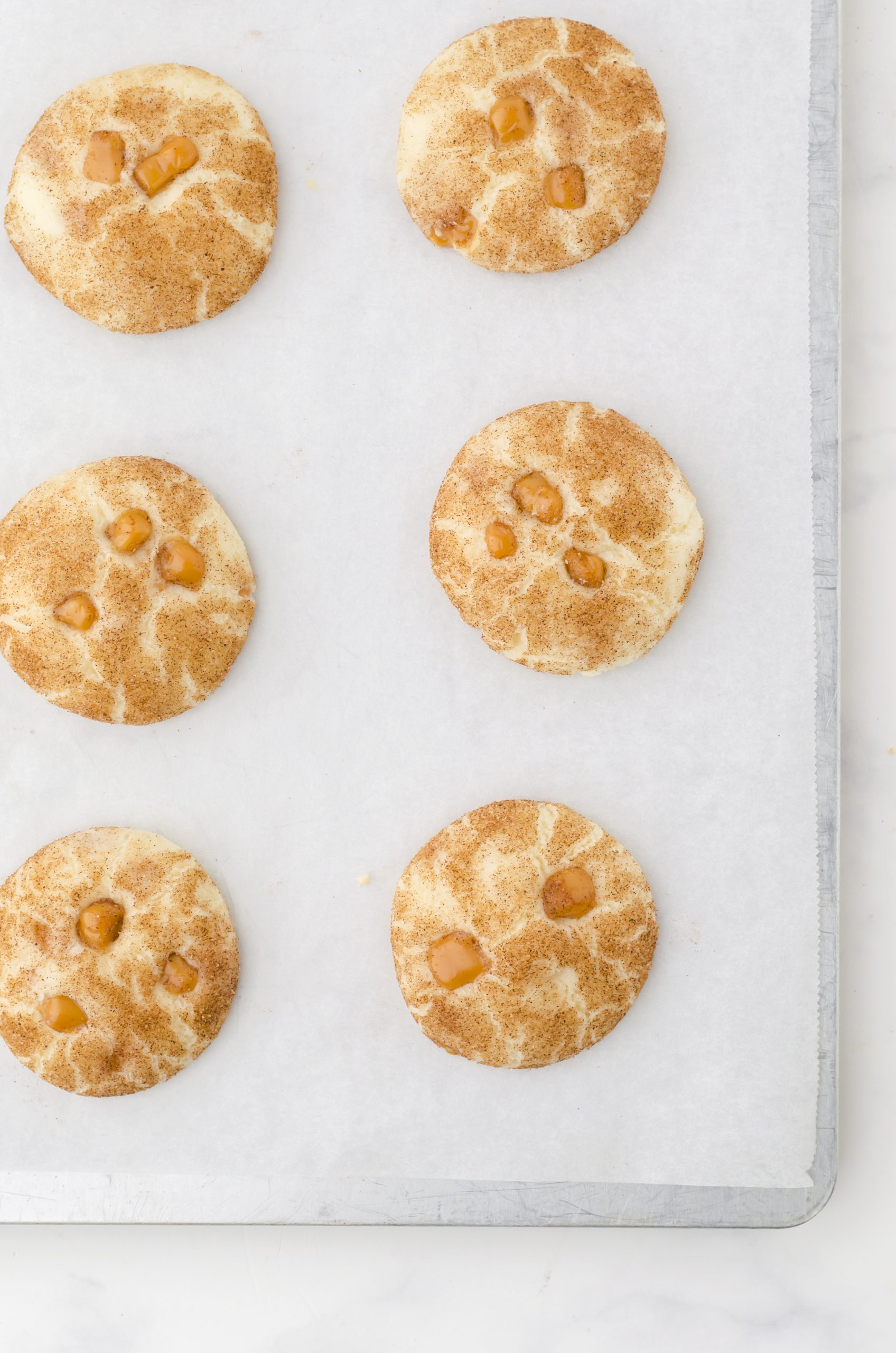 a cookie sheet lined with parchment paper with baked cookies on it