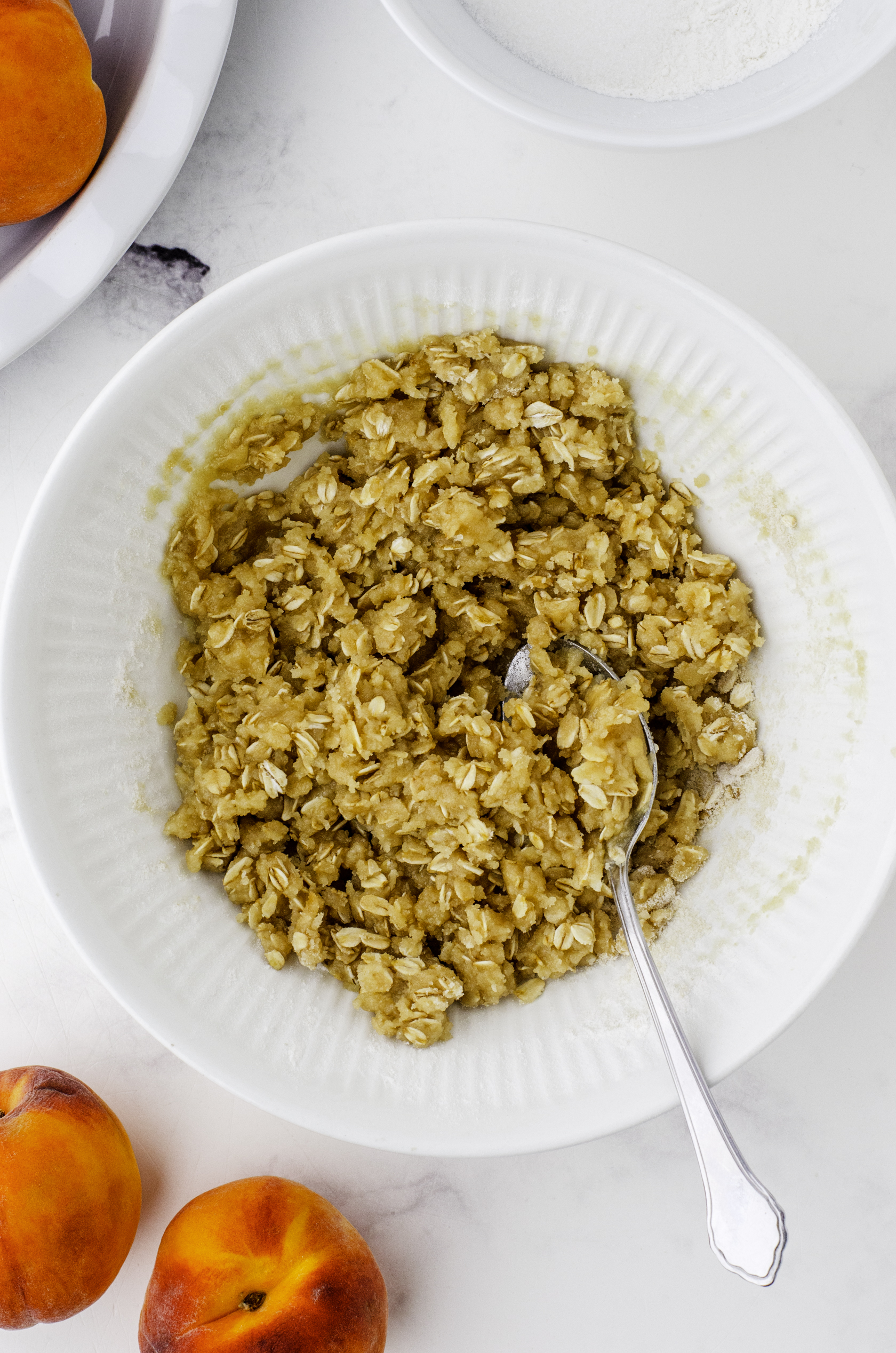 The mixed oat topping for peach crisp in a mixing bowl