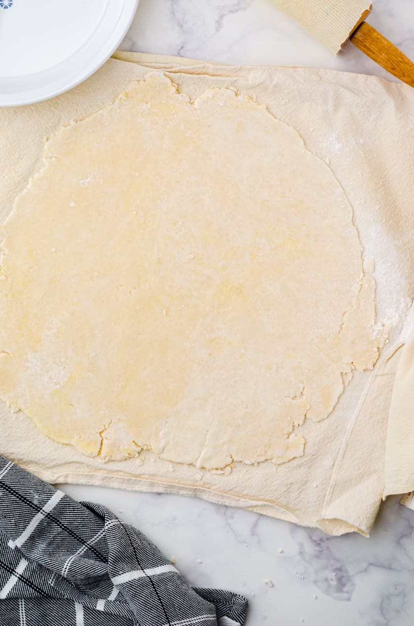 Pie crust rolled on a pastry cloth.