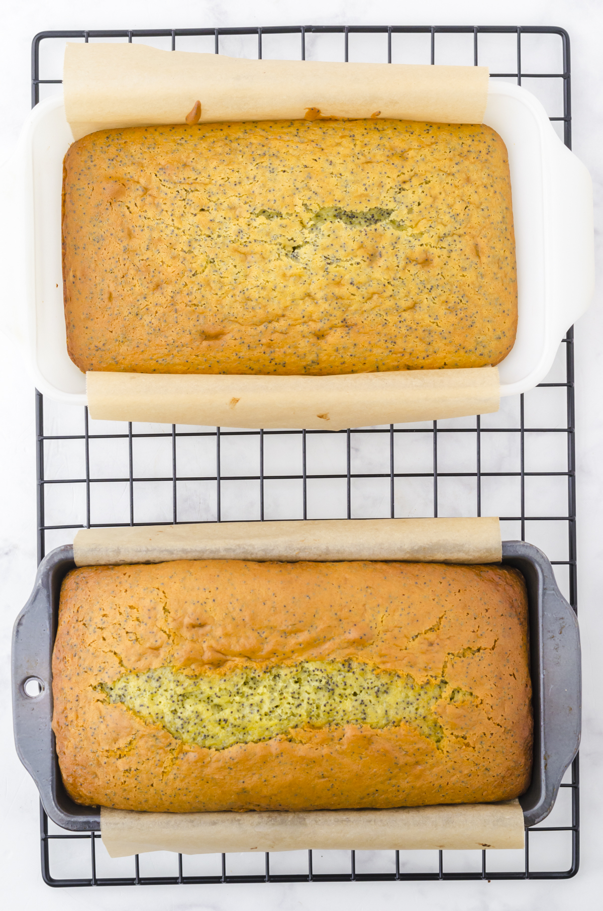 2 loaves of poppy seed bread with cake mix in loaf pans cooling on a wire rack