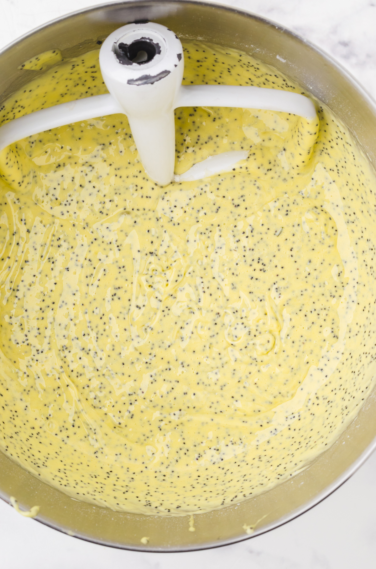 Poppy seed bread batter mixed together in a mixing bowl.