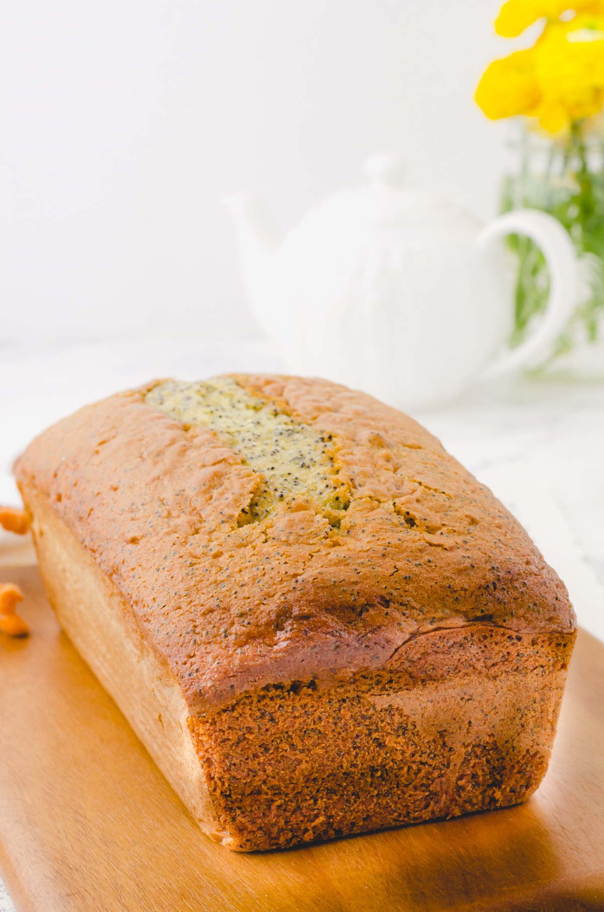 A loaf of poppyseed bread with cake mix on a cutting board