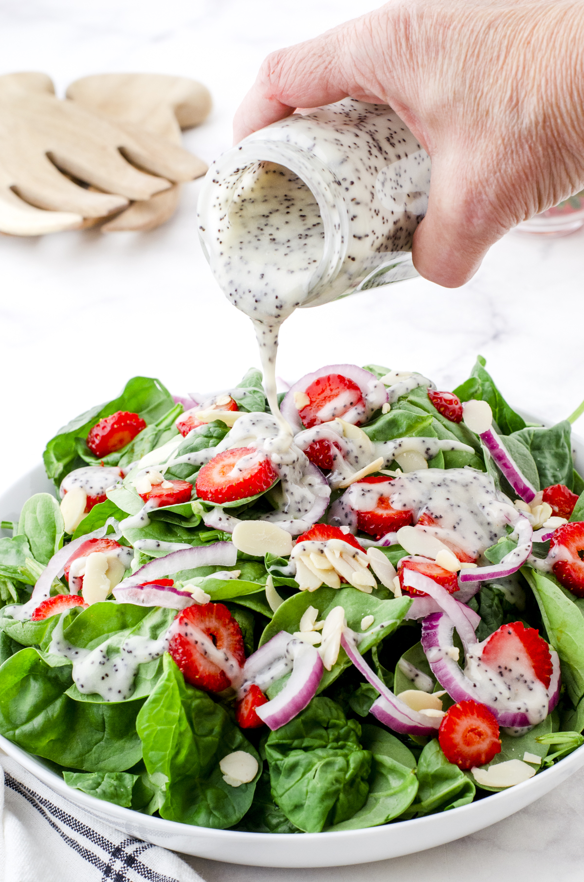 Strawberry poppyseed salad in a white bowl.