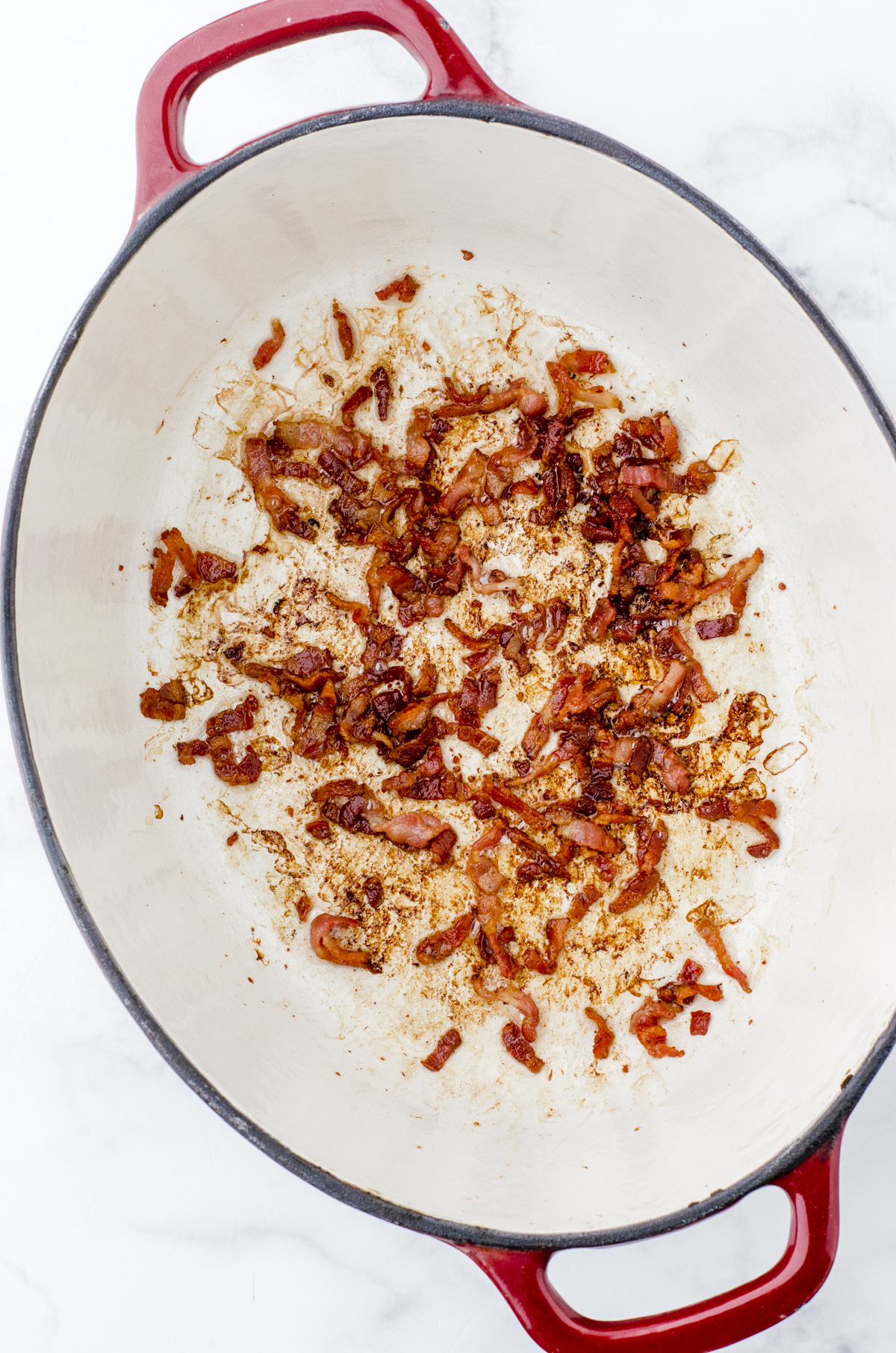 Crispy bacon in the bottom of an enamel cast iron dutch oven.