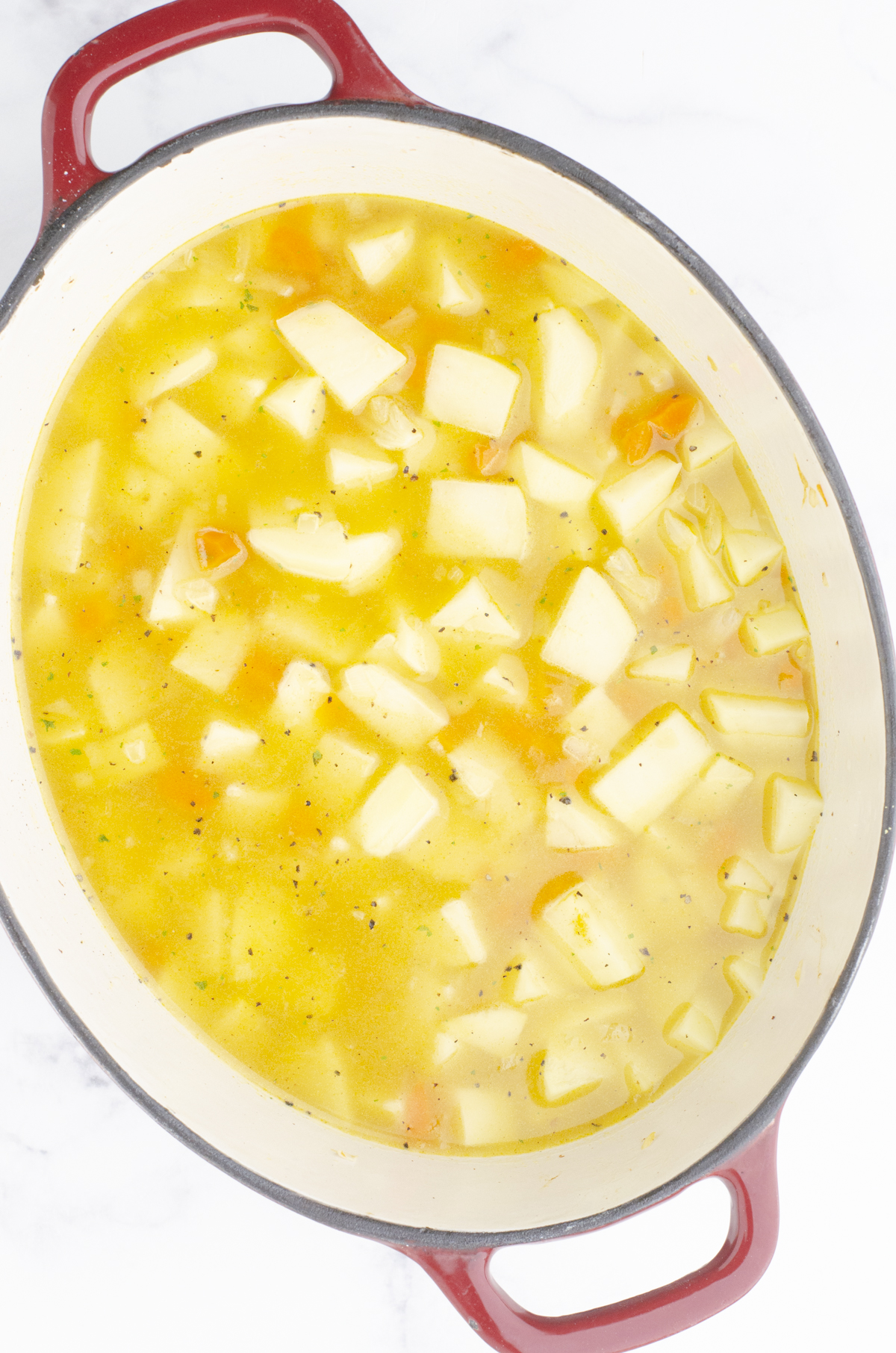 Potato soup ingredients all in a large dutch oven.