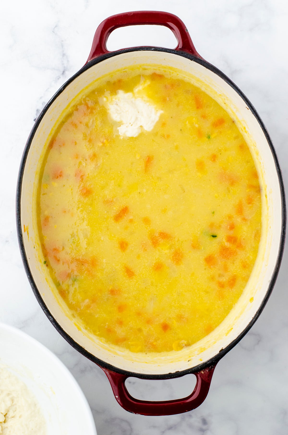 Drop dumpling dough on the top of a pot of potato soup.