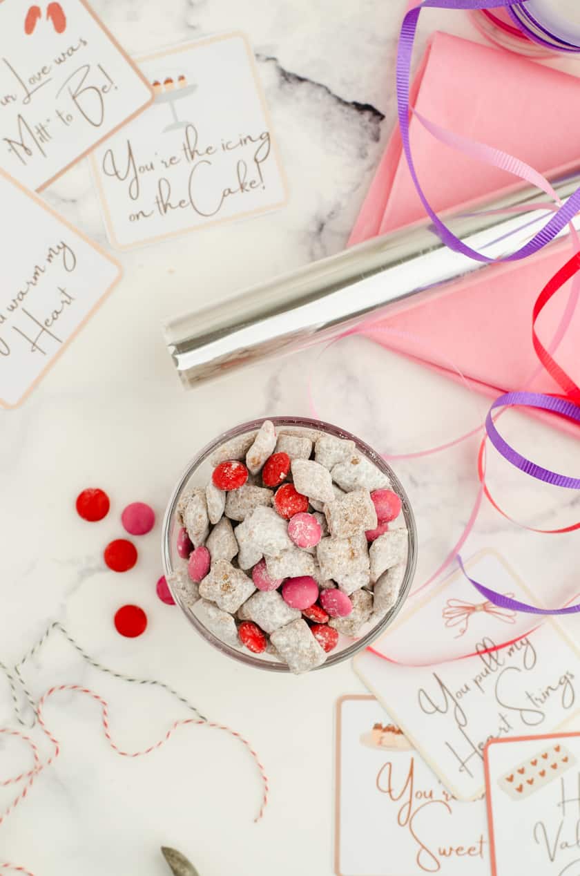 A bowl of Valentines puppy chow mix with a stack of free valentines tags beside it