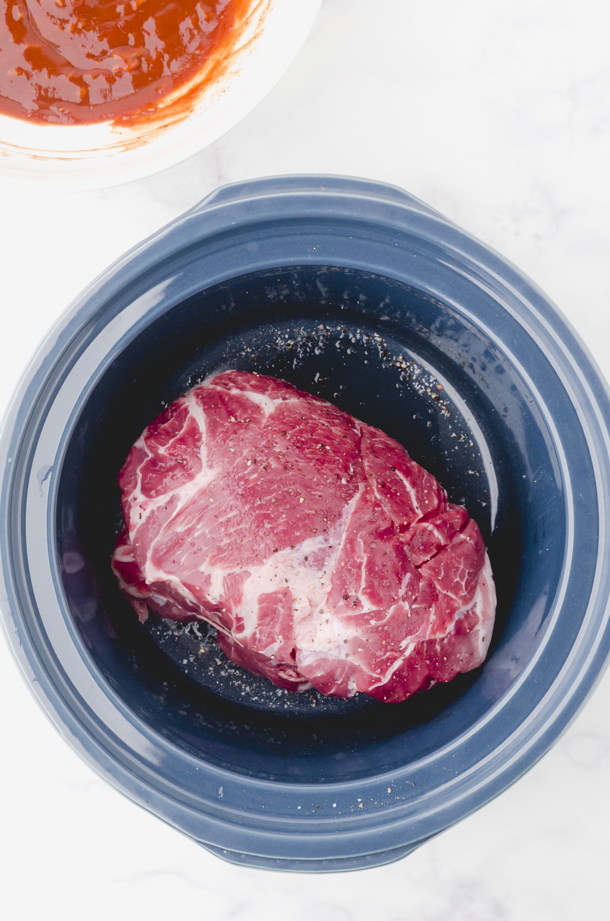 Pork roast in the bottom of a crock pot for this pulled.pork recipe