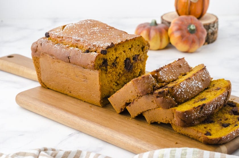 Cake mix pumpkin bread sliced on a wooden cutting board.