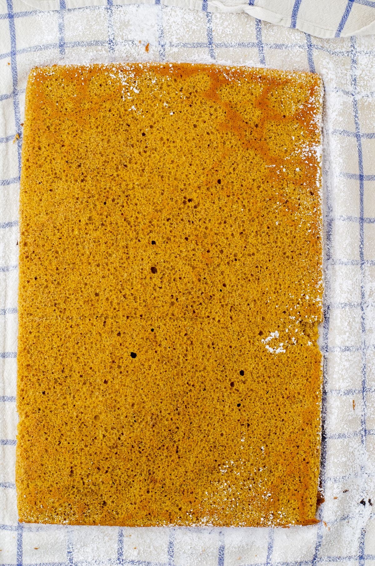 pumpkin cake for pumpkin cake roll on a powdered sugar covered tea towel