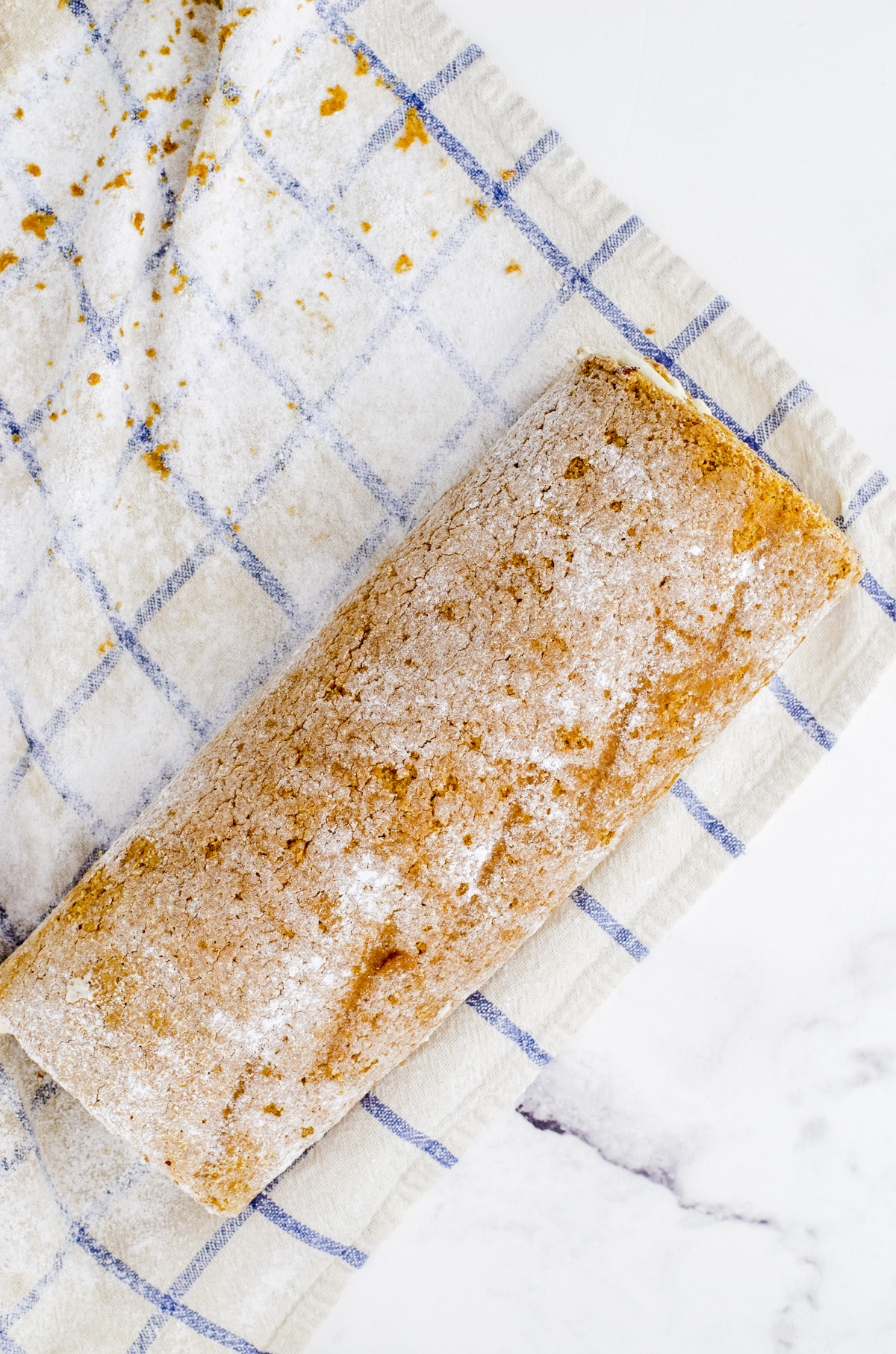 pumpkin cake roll after it has been rolled up with frosting inside.