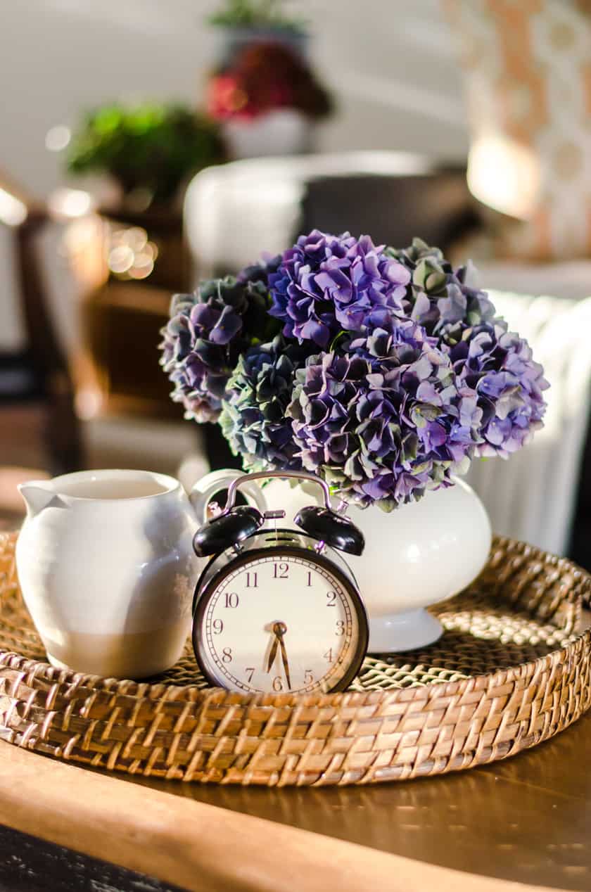 Coffee table decor perfect for Fall with a farmhouse boho look - a vase of flowers, stoneware pitcher, and vintage look clock.