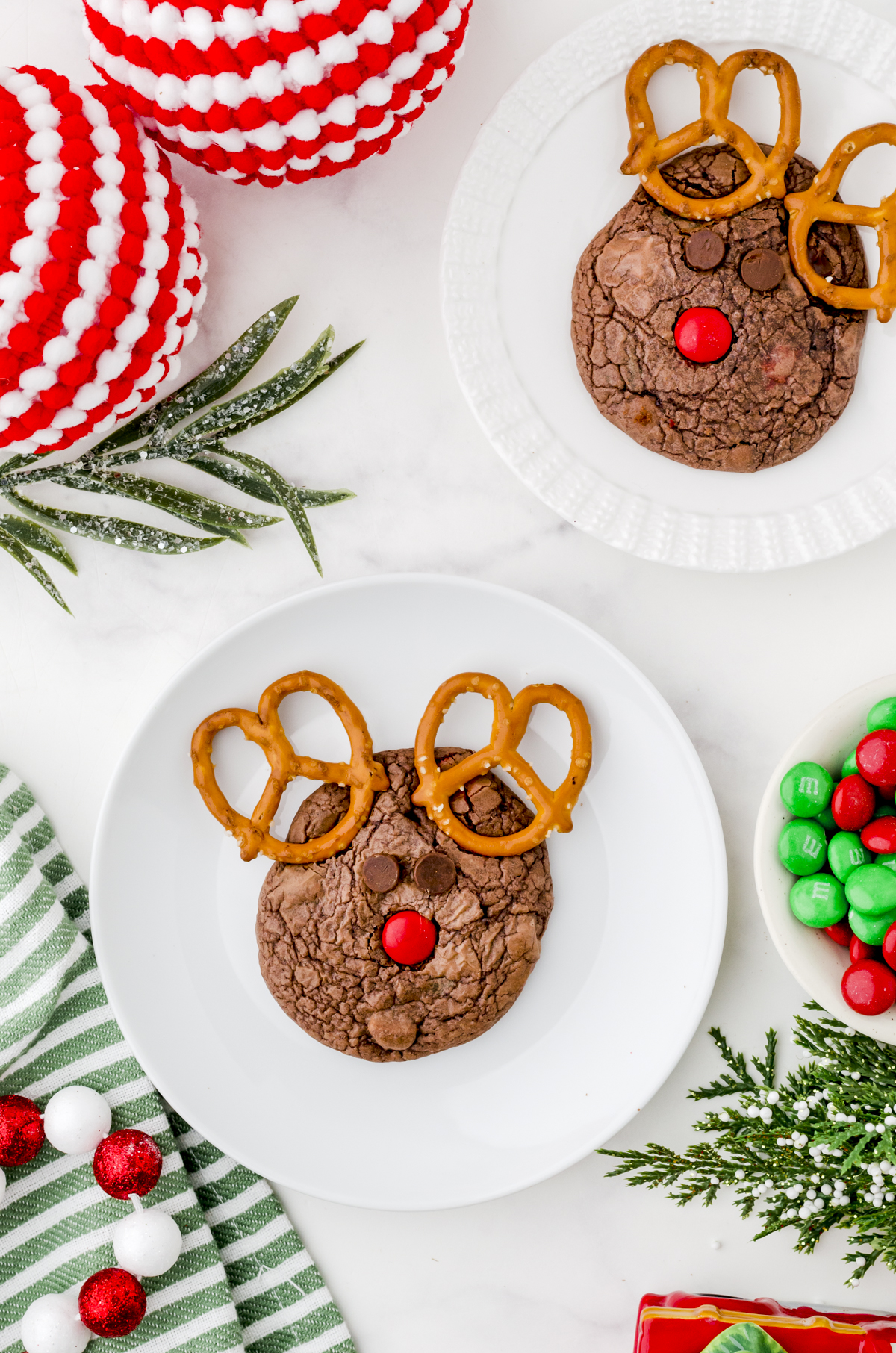 Rudolph cookies on plates with a bowl of red and green m&ms on the side