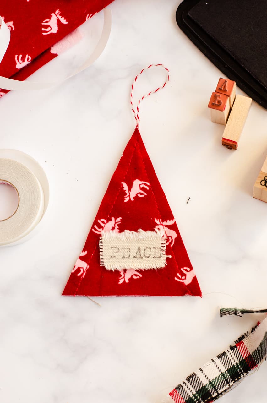 Stamp personalized words on the fabric message tag of these DIY Scandinavian inspired ornaments. This one says "Peace".