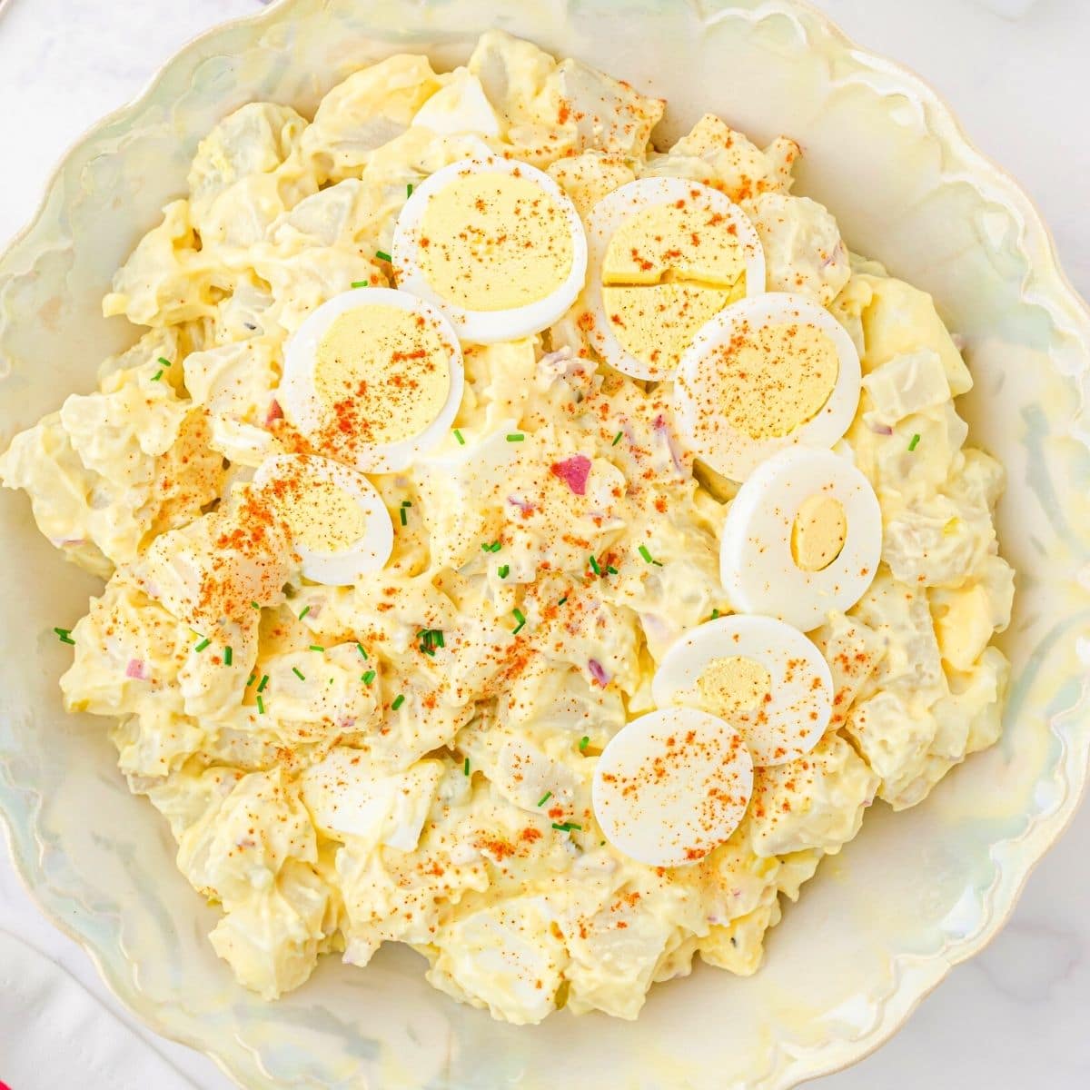 A bolw of potato salad with egg as garnish on the top