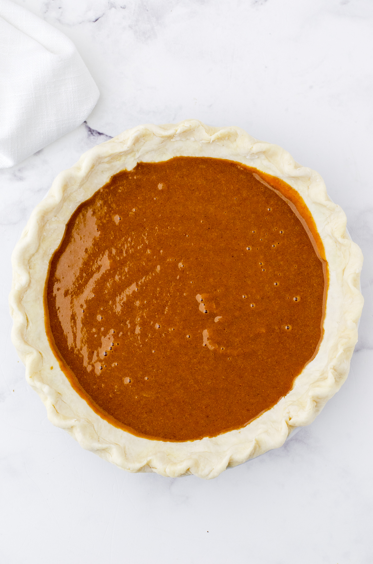 pumpkin pie filling poured into an unbaked pie shell