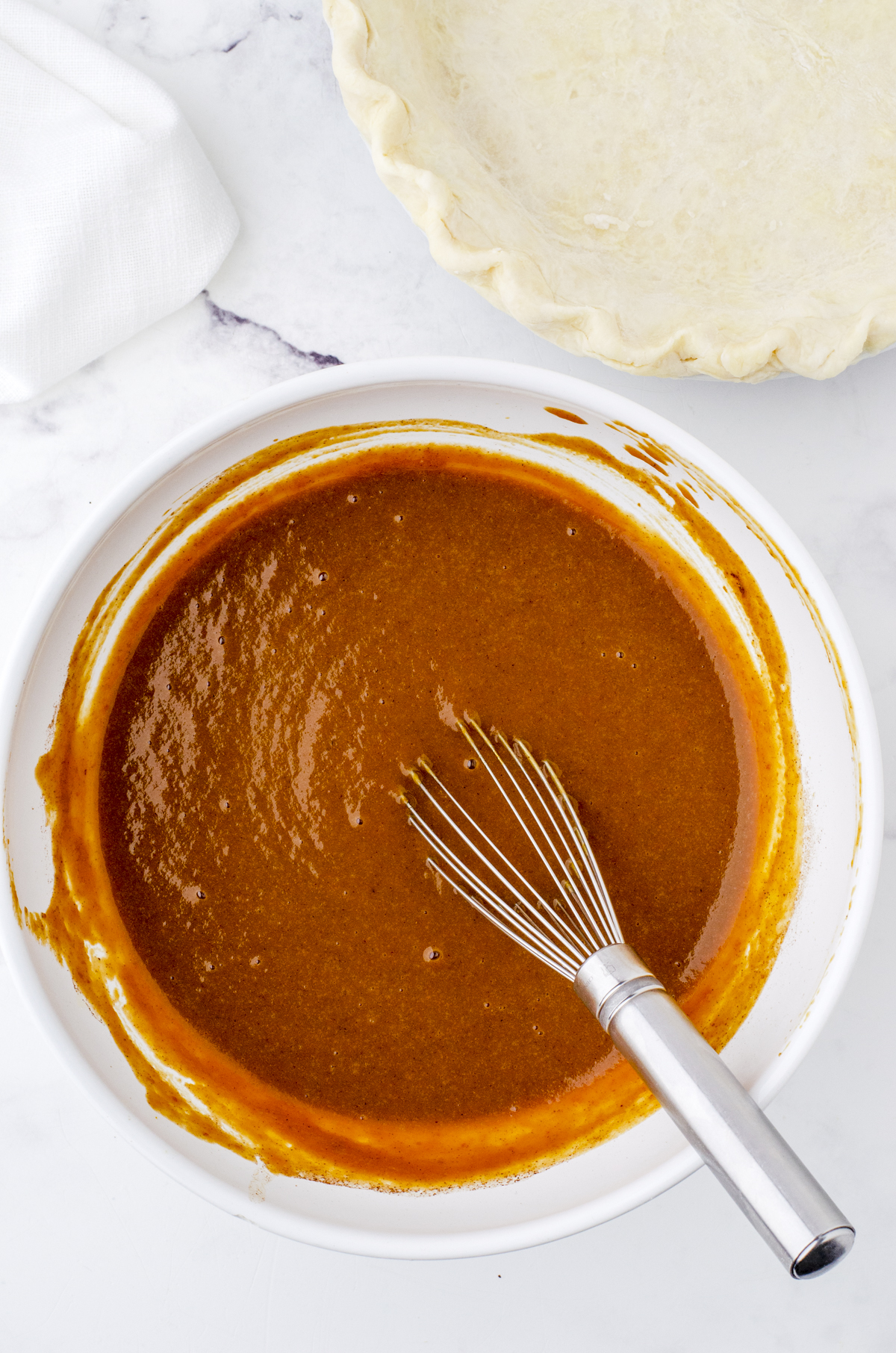 old fashioned pumpkin pie filling being whisked in a bowl