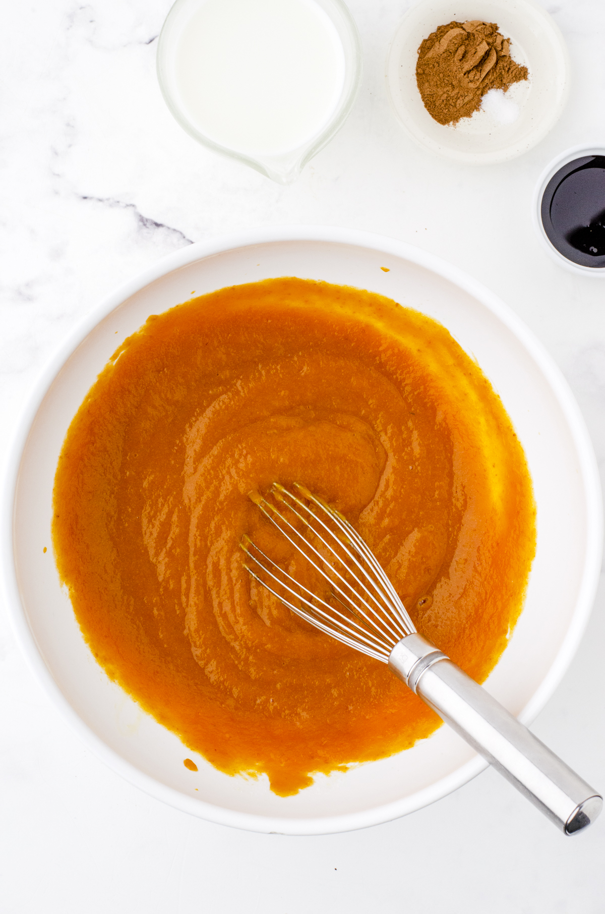 Pumpkin pie filling being whisked in a bowl