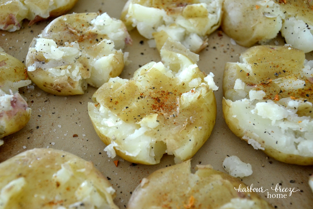 Smashed baby potatoes with spices before they are baked.
