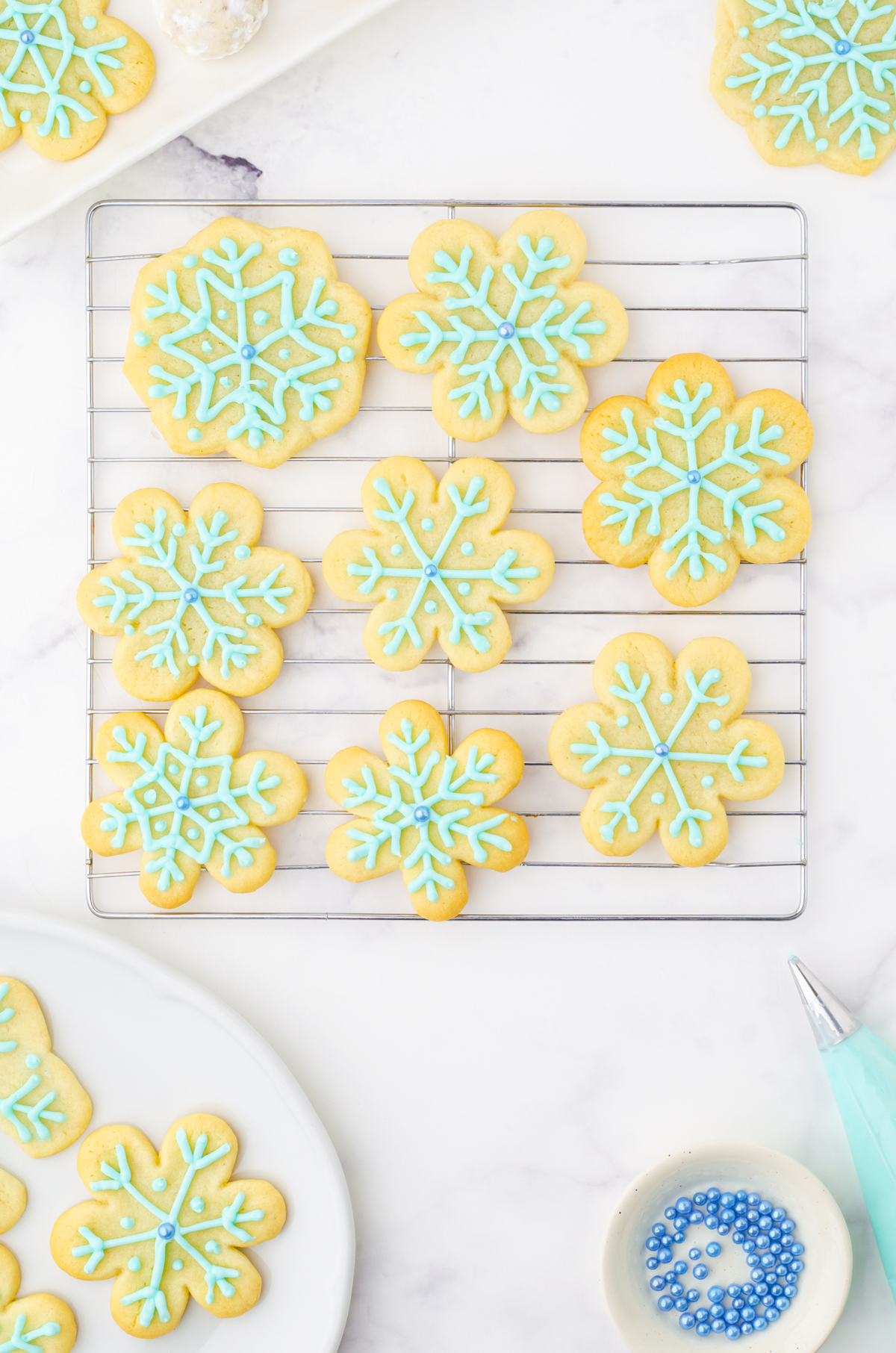 Snowflake sugar cookies on a wire cooling rack.