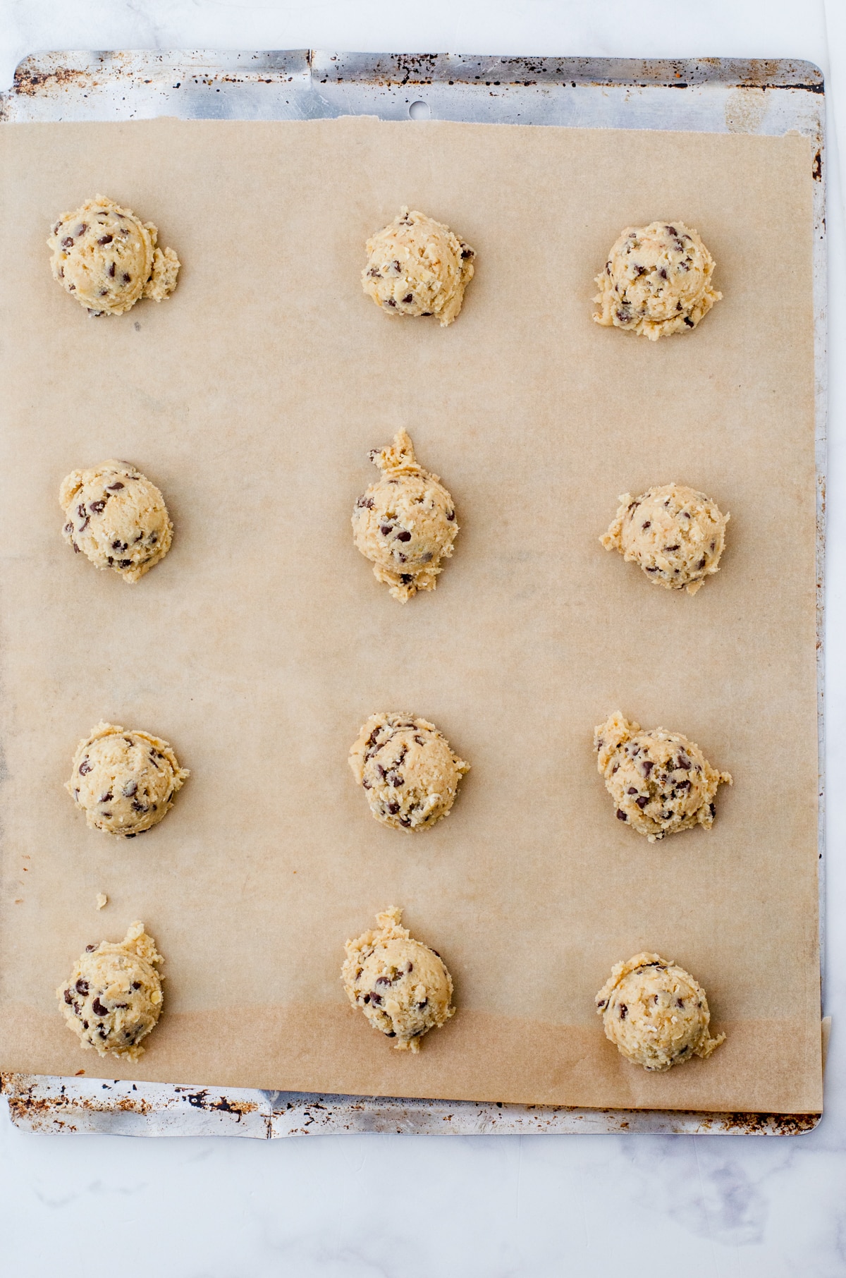 Cookie dough dropped onto parchment lined cookie sheet