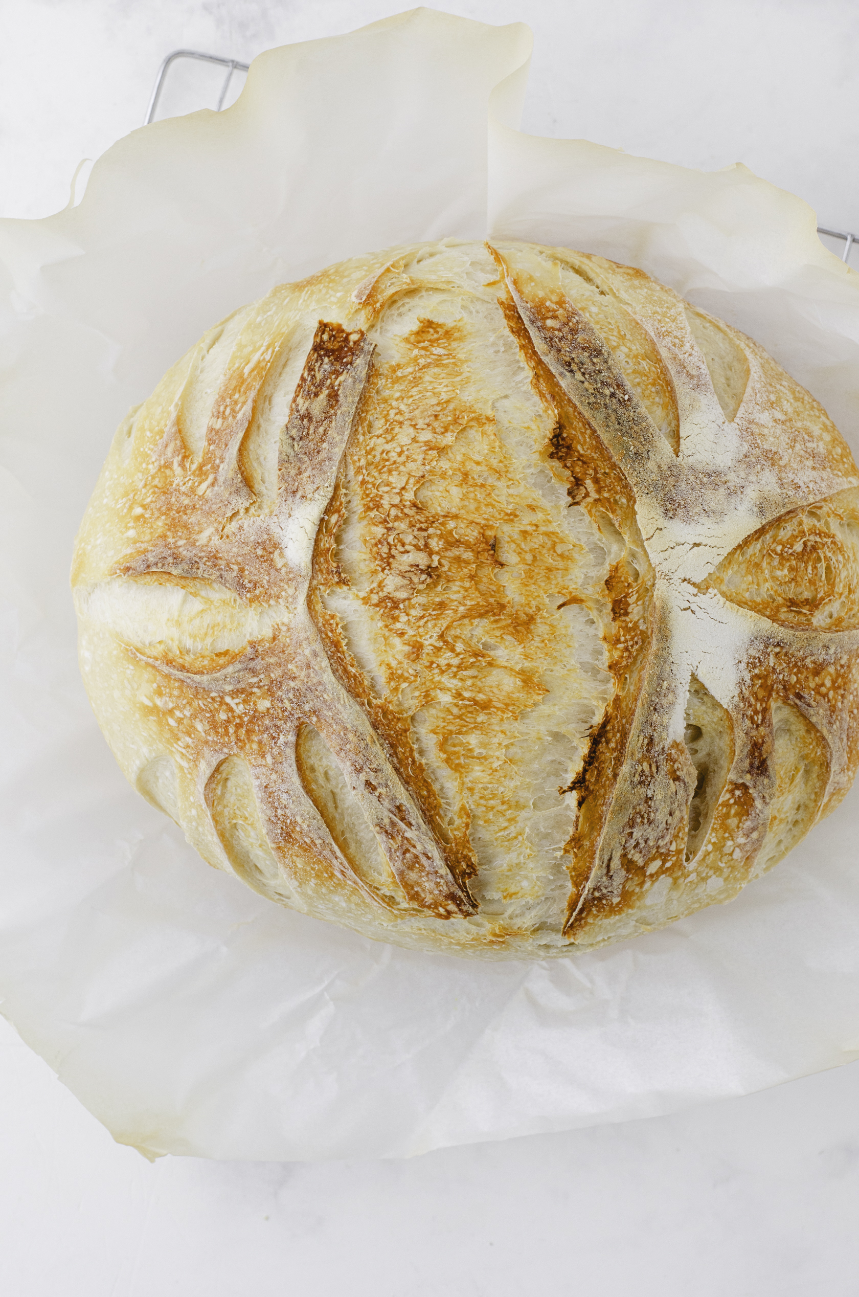 A baked sourdough loaf after it has been removed from the dutch oven.