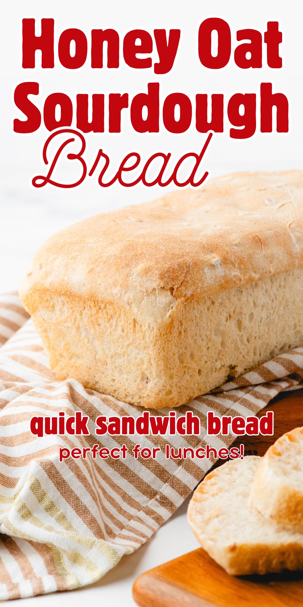 A loaf of sourdough sandwich bread on a striped cloth
