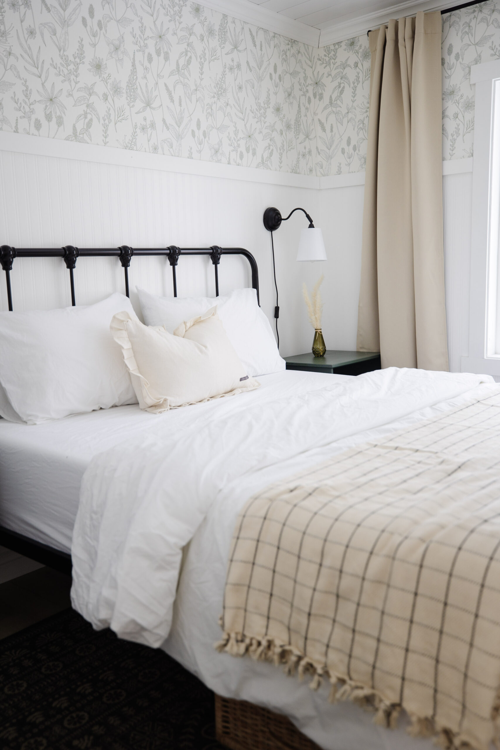 a bed made with beautiful white bed sheets and a throw blanket at the bottom of it.