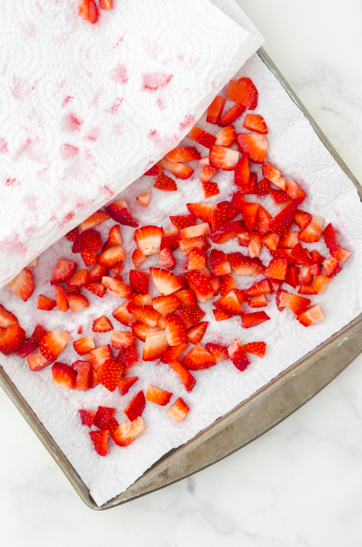 fresh strawberries diced and placed on a tray with paper towel
