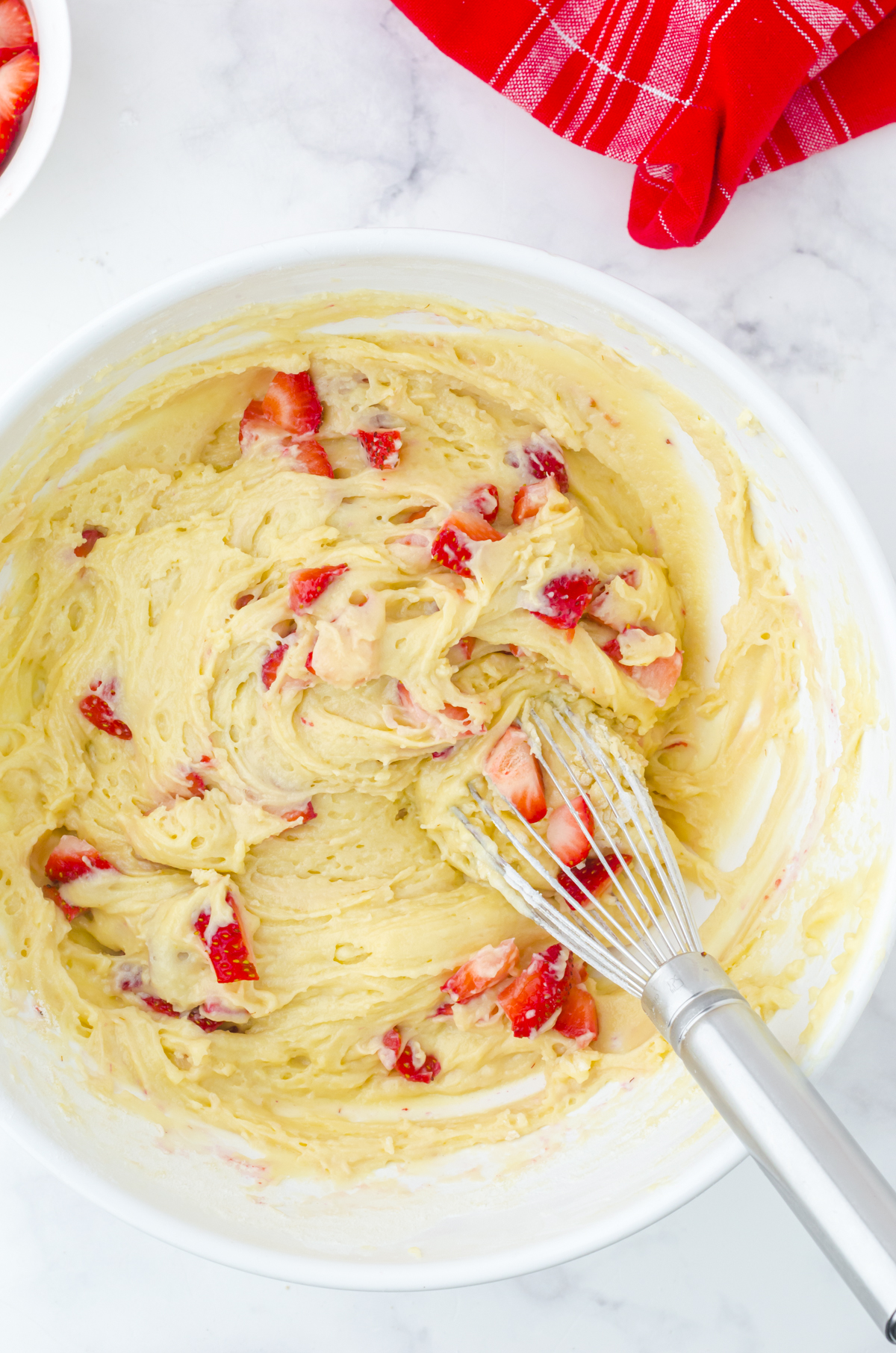 Folding the strawberries into the muffin batter.