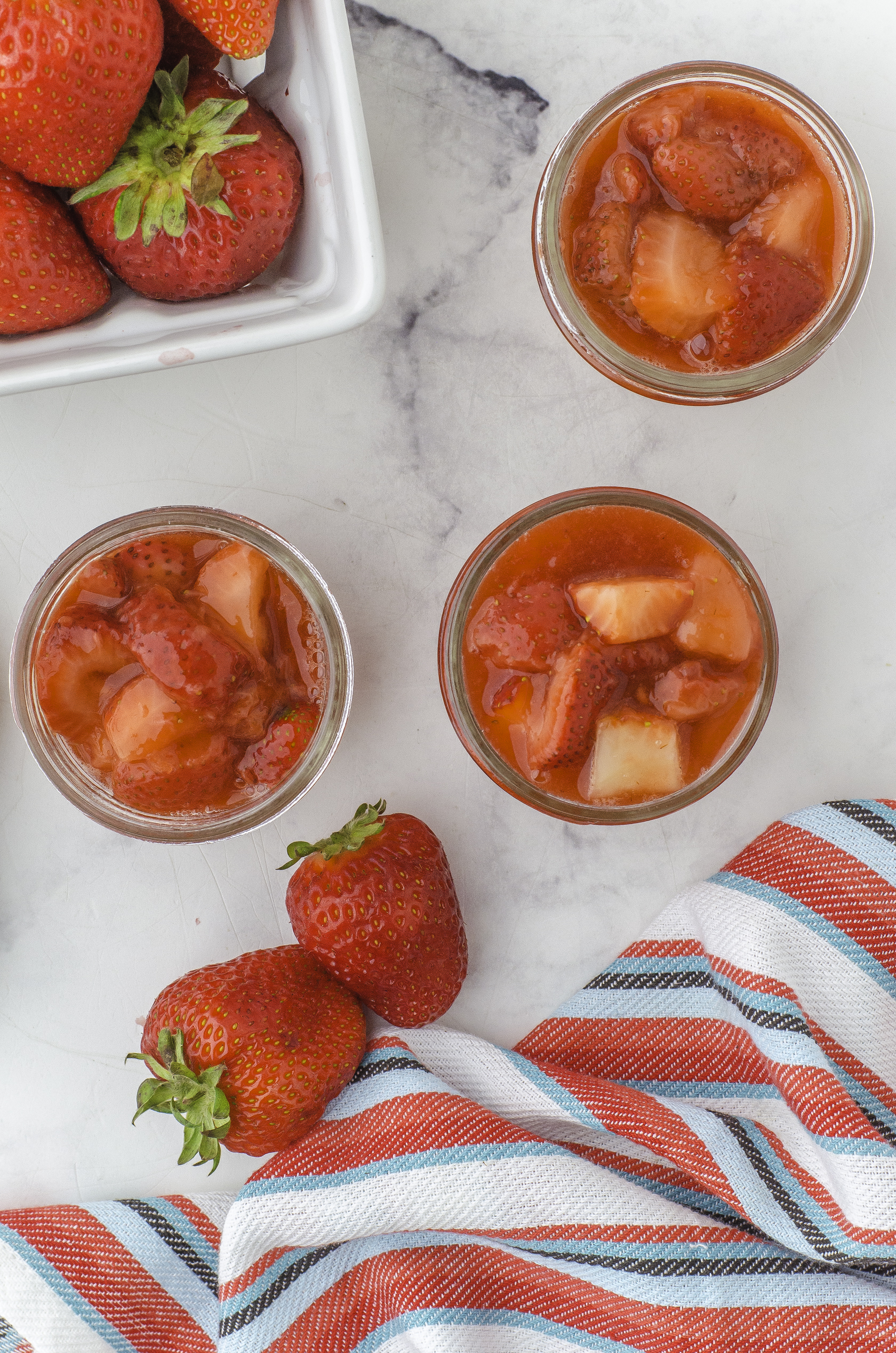 Strawberry sauce in 3 125 ml (small) mason jam jars.