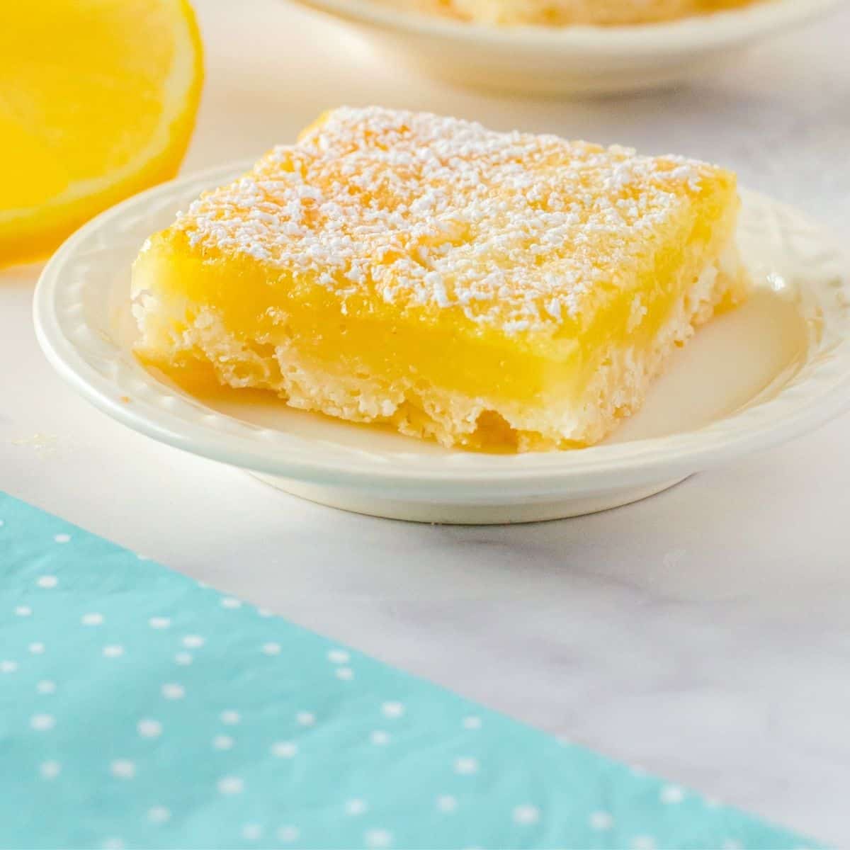 A lemon square sitting on a plate