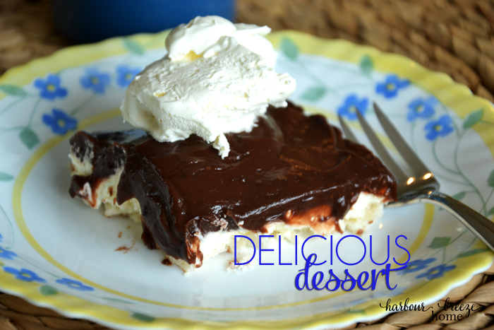 Cream cheese pudding dessert (also called Delicious Dessert) sliced on a plate.