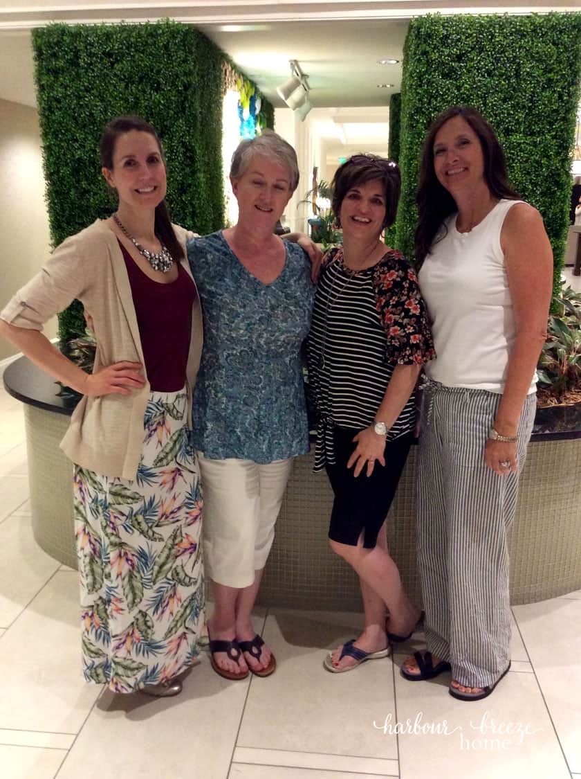 picture of 4 women in front of greenery