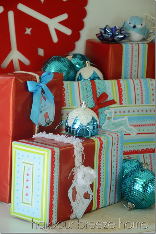 wrapped gifts in aqua blue and white paper on an entryway table as Christmas decor.