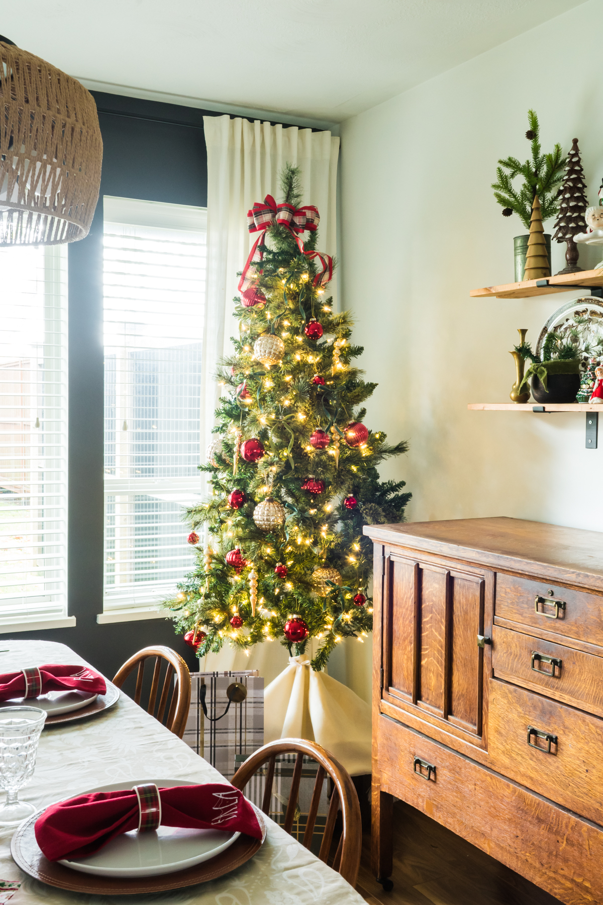 Christmas tree on a box beside and antique buffet
