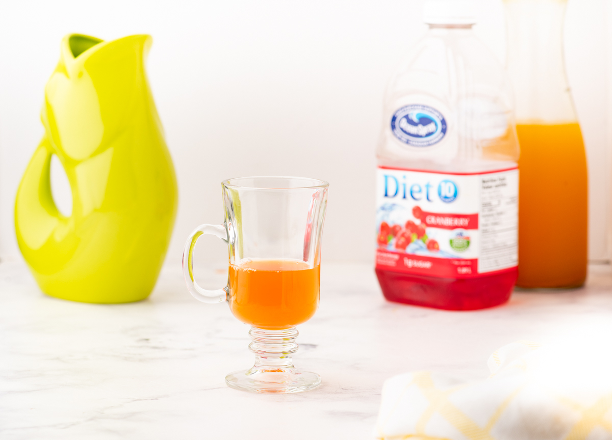 tumeric tea concentrate in a cup with some cranberry juice.