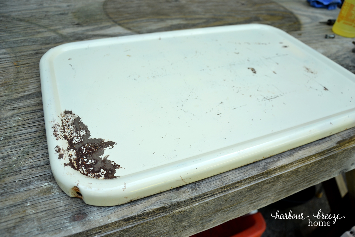rusty tray of a vintage metal cart that has been removed from the 3 tier rolling cart