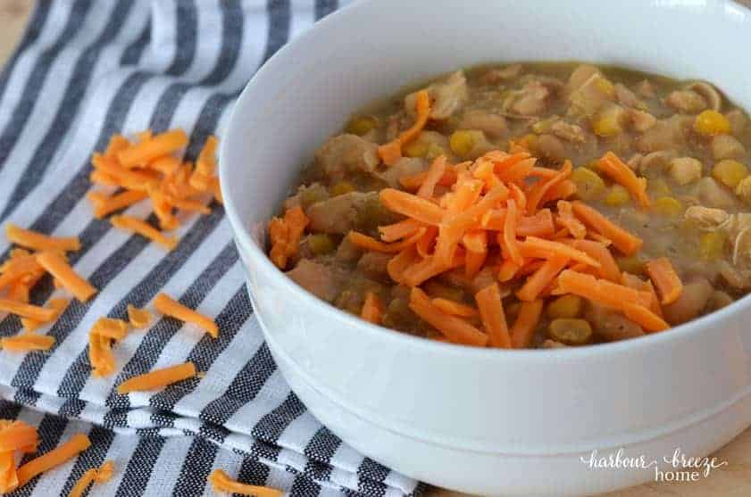 A bowl of white chicken chili with grated cheese is hot and ready to eat!