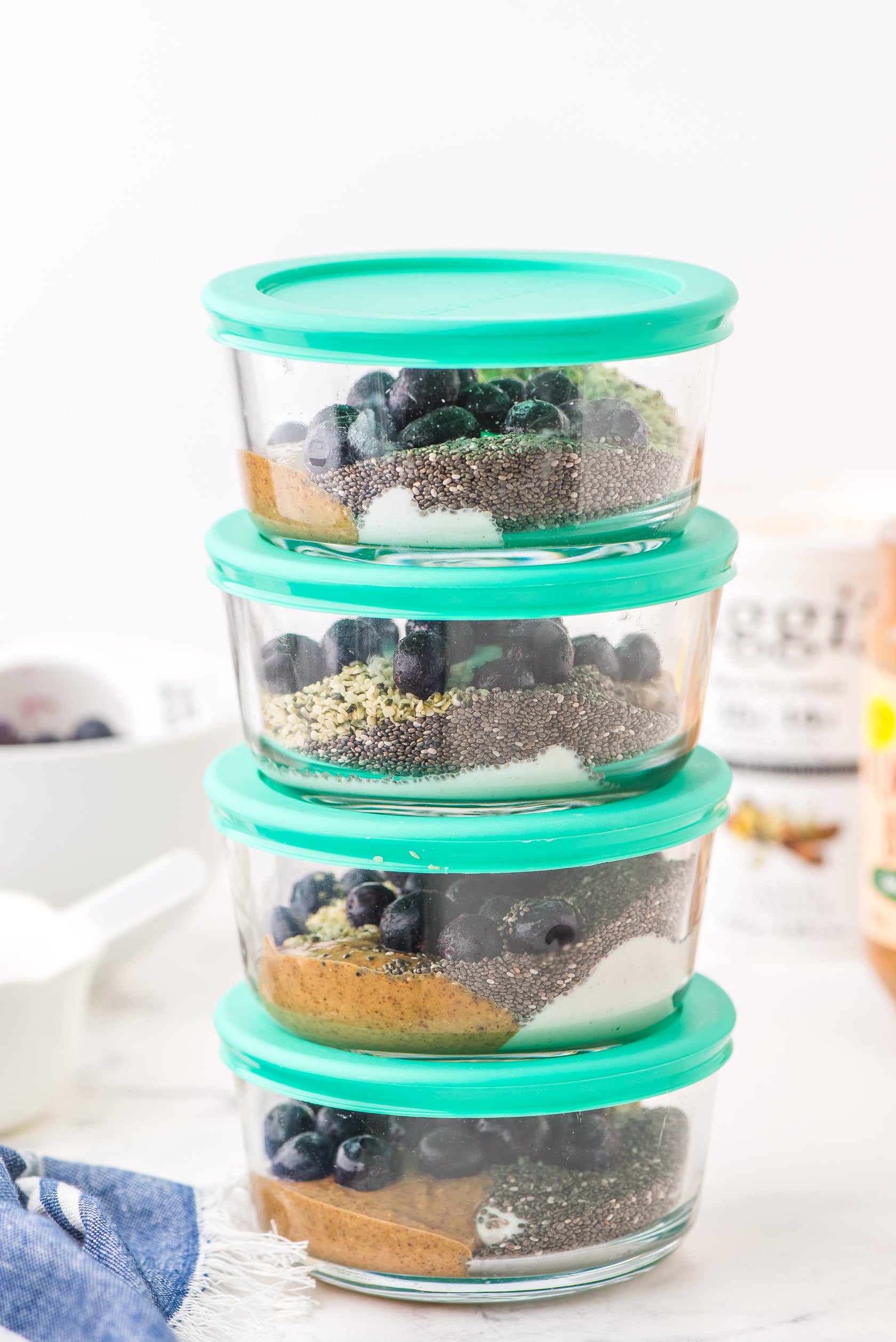 A stack of yogurt bowls with green lids.