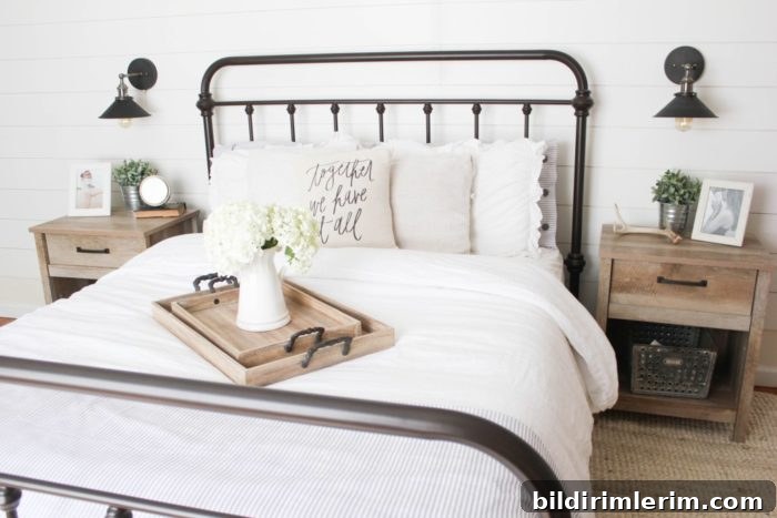 Stylish Modern Farmhouse Bedroom Ideas 2 Farmhouse bedroom with metal bedframe, white shiplap wall behind, wood toned nightstands beside, and black wall mounted sconce lights above the nightstands.