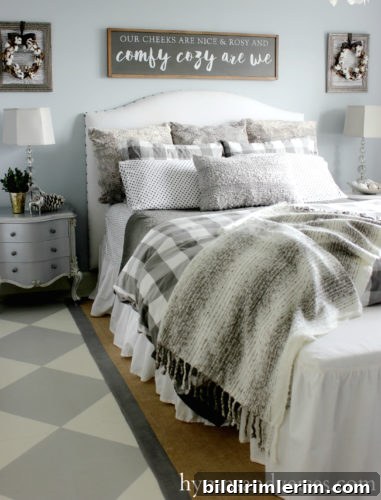 Stylish Modern Farmhouse Bedroom Ideas 4 Farmhouse bedroom with white upholstered headboard on bed; a light blue wall behind, and gray bedding and pillows.