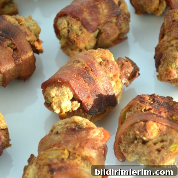 bacon wrapped stuffing balls baked on a baking sheet