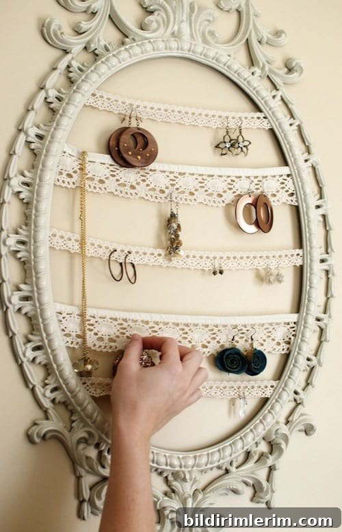 a vintage frame hung on the wall with crocheted lace strips becomes the perfect spot for hanging earrings